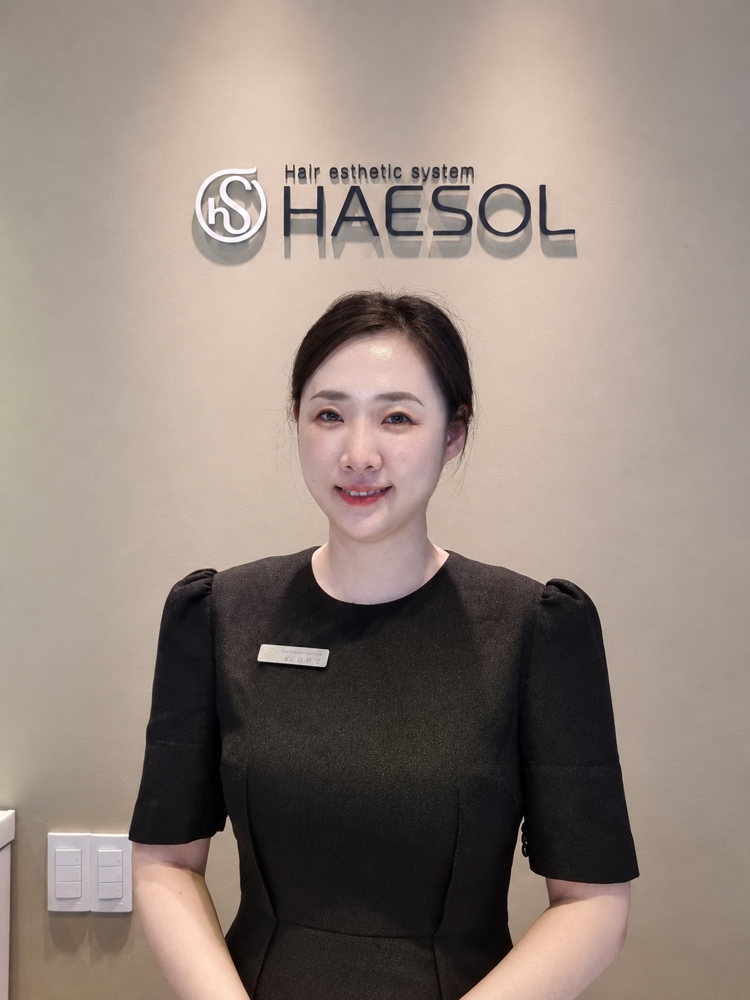 헤솔 로고 앞 중앙에 선 헤솔두피클리닉스 서면점 원장
